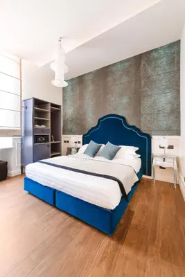 a bedroom with a large blue bed in a room at DC Collection Spagna in Rome
