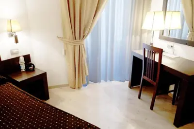 a hotel room with a desk and a chair at Roman Residence in Rome