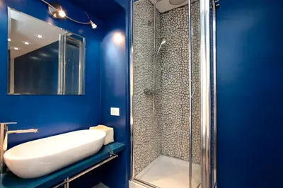 a blue bathroom with a sink and a shower at Rome Services Borgo Suites in Rome