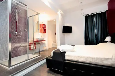 a bedroom with a shower and a bed with a glass door at Rome Services Borgo Suites in Rome