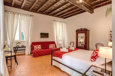 a bedroom with a bed and a red couch at Piccolo Trevi Suites in Rome