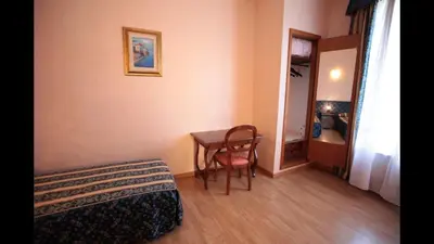 a room with a bed and a table with a chair at Residenza Matilde in Rome