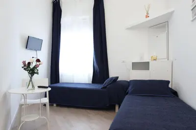 a small bedroom with a blue bed and a table at B&B Roma Olimpic in Rome