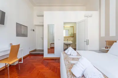 a bedroom with a bed and a desk and a table at Easybnb - Dea Roma in Rome