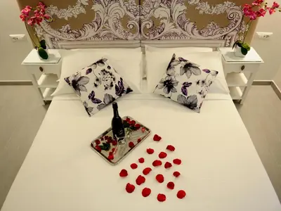 a bed with a bottle of wine and a tray of hearts at Easyrome Guest House in Rome