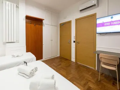 a hotel room with two beds and a projection screen at B&B Hotel Roma Italia Viminale in Rome