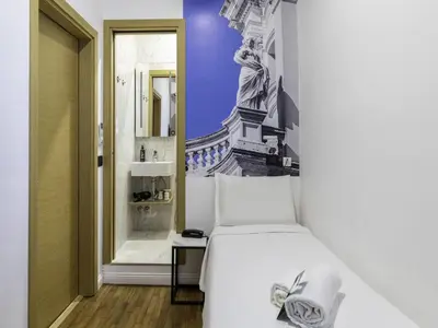 a bedroom with a white bed and a bathroom at B&B Hotel Roma Italia Viminale in Rome