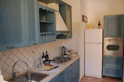 a kitchen with blue cabinets and a sink and a refrigerator at La Piazzetta di Roma in Rome