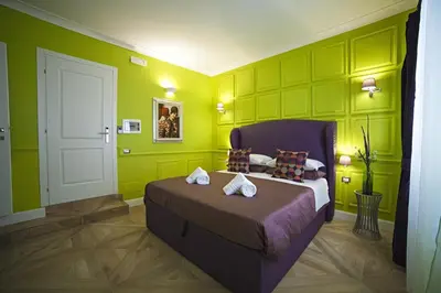 a bedroom with a bed in a room with green walls at Vatican Luxury Home in Rome