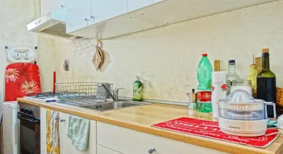 a kitchen with a sink and a counter top with bottles at Gite House in Rome