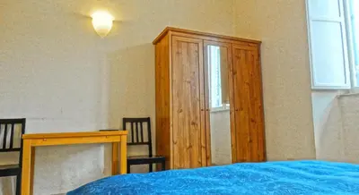 a bedroom with a wooden cabinet next to a bed at Gite House in Rome