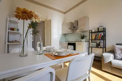 a kitchen with a table with a vase of flowers at Vatican Suite Carolina Holiday Apartment in Rome