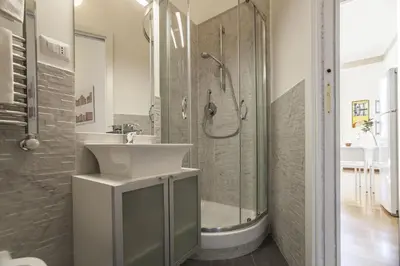 a white bathroom with a sink and a shower at Vatican Suite Carolina Holiday Apartment in Rome