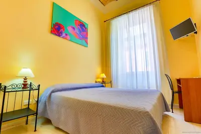 a yellow bedroom with a bed and a window at Gordon's Apartment in Rome