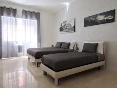 two beds in a bedroom with a window at Roema Guest House in Rome