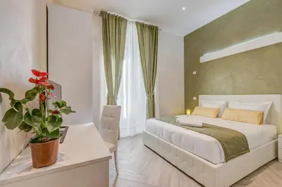 a bedroom with a large bed and a potted plant at Penta Luxury House in Rome