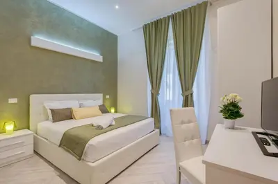 a bedroom with a bed and a desk and a television at Penta Luxury House in Rome