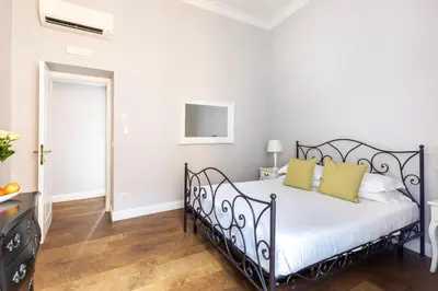 a bedroom with a black bed with yellow pillows at Spagna Art & Suites - CA Domus Collection in Rome
