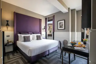 a hotel room with a large bed and a table at The Tribune, part of JdV by Hyatt in Rome