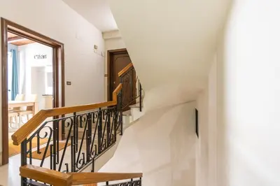 a staircase in a home with white walls and wooden railings at Piazza Navona Lovely Apartment in Rome