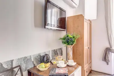 a kitchen with a table and a mirror on the wall at La Casa Di Amy in Rome