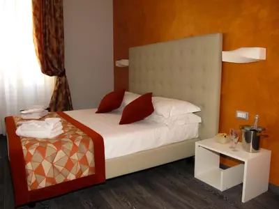 a bedroom with a bed with white sheets and red pillows at Roma Veneto Relais in Rome