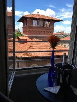 a vase with a flower on a table in front of a window at Roma Veneto Relais in Rome