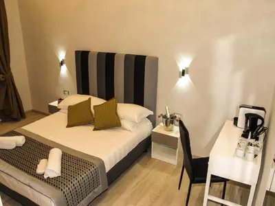 a small bedroom with a bed and a table at Roma Veneto Relais in Rome