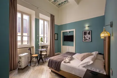 a bedroom with blue walls and a bed and a table at My Trevi Charming & Luxury Rooms in Rome