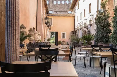 a restaurant with tables and chairs in a building at Il Monastero Collection in Rome