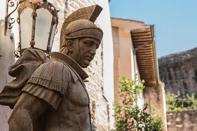 a statue of a man standing next to a building at Il Monastero Collection in Rome