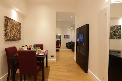 a dining room with a table and a television at Sant'Angelo Exclusive Spacious Art in Rome