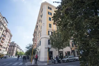 a tall yellow and white building on a city street at AS Planet in Rome
