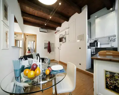 a dining room and kitchen with a glass table with fruit on it at River View Apartment in Rome