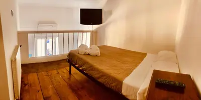a bedroom with a bed and a television on the wall at Heart of Rome Vatican Deluxe New Apartment 1GB WiFi in Rome