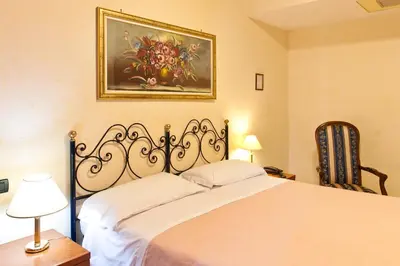 a bedroom with a bed and a painting on the wall at Hotel Stromboli in Rome