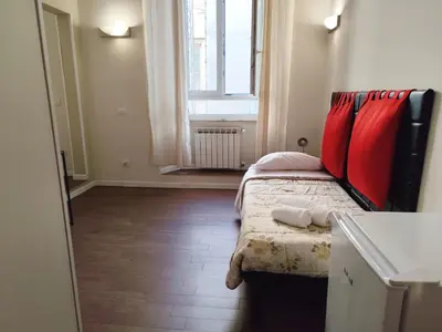 a bedroom with a bed with red pillows and a window at Milazzo23 Guesthouse in Rome