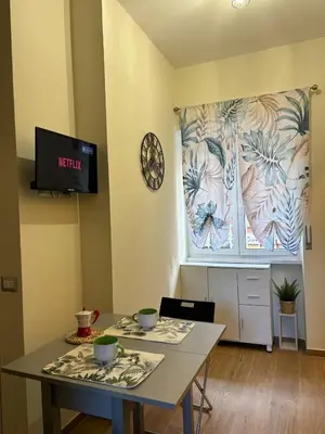 a dining room with two tables and a clock on a wall at Casa Blaserna nel Cuore dello Shopping a Marconi e Trastevere in Rome
