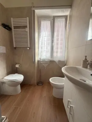 a white bathroom with a toilet and a sink at Casa Blaserna nel Cuore dello Shopping a Marconi e Trastevere in Rome