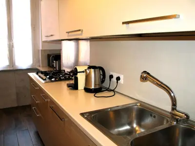 a kitchen counter with a sink and a stove at Roman Home Base in the Appio Latino in Rome