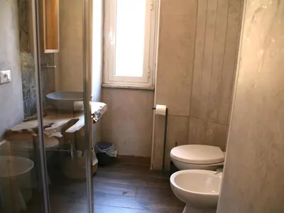 a bathroom with a toilet and a sink and a window at Roman Home Base in the Appio Latino in Rome