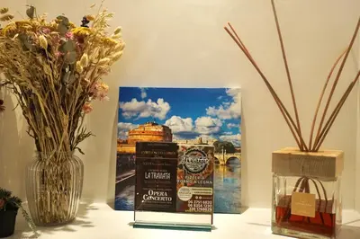 a table with a bottle of whiskey and a picture of a bridge at Hotel Vespasiano in Rome