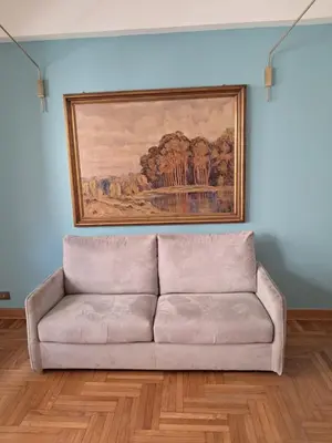 a couch in a living room with a painting on the wall at RoRo Roma in Rome