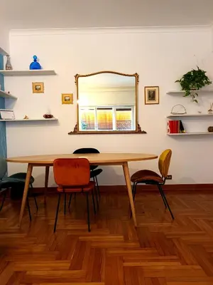 a dining room table with chairs and a mirror at RoRo Roma in Rome