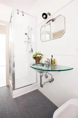 a bathroom with a glass sink and a shower at Dandy Suite in Rome