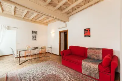 a living room with a red couch and a table at A Window on Pantheon in Rome