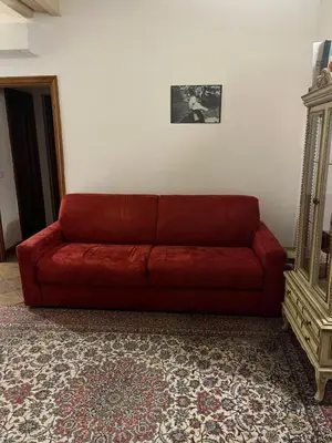 a red couch sitting in a living room at A Window on Pantheon in Rome