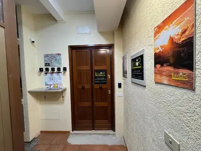 a hallway with a wooden door in a building at LUXOR ECO ROMA CASA E APPARTAMENTO PER VACANZE IN CENTRO Piazza Bologna, Colosseo, Piazza di Spagna, Vaticano, San Pietro, Sapienza, Fontana di Trevi, Piazza Navona, Trastevere, Tiburtina, Termini, Aeroporto in Rome