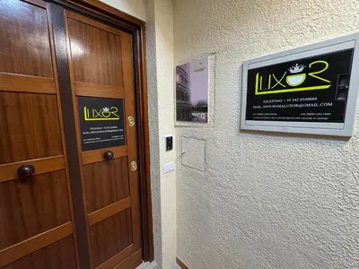 a door in a room with a sign on the wall at LUXOR ECO ROMA CASA E APPARTAMENTO PER VACANZE IN CENTRO Piazza Bologna, Colosseo, Piazza di Spagna, Vaticano, San Pietro, Sapienza, Fontana di Trevi, Piazza Navona, Trastevere, Tiburtina, Termini, Aeroporto in Rome