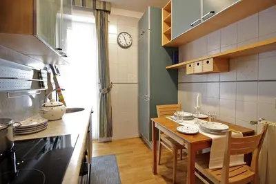 a kitchen with a table and a clock on the wall at Appartamento con Terrazza vicino Gemelli e Vaticano in Rome